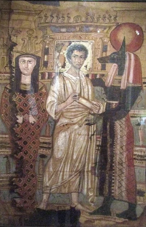 Mural of three figures: a woman in patterned clothing on the left, a young man in beige clothing in the center, and a figure with a long beak and red attire on the right, set against a decorated background.
