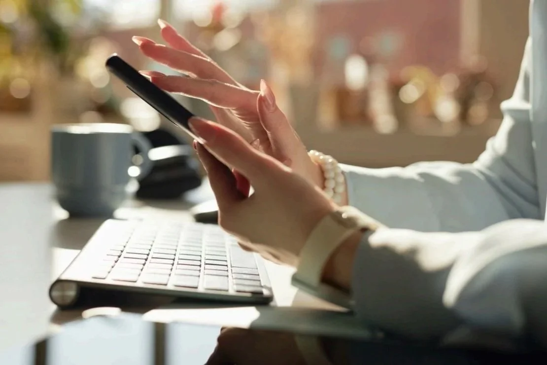 Person scrolling on a smartphone at a desk representing situational attention in digital marketing.