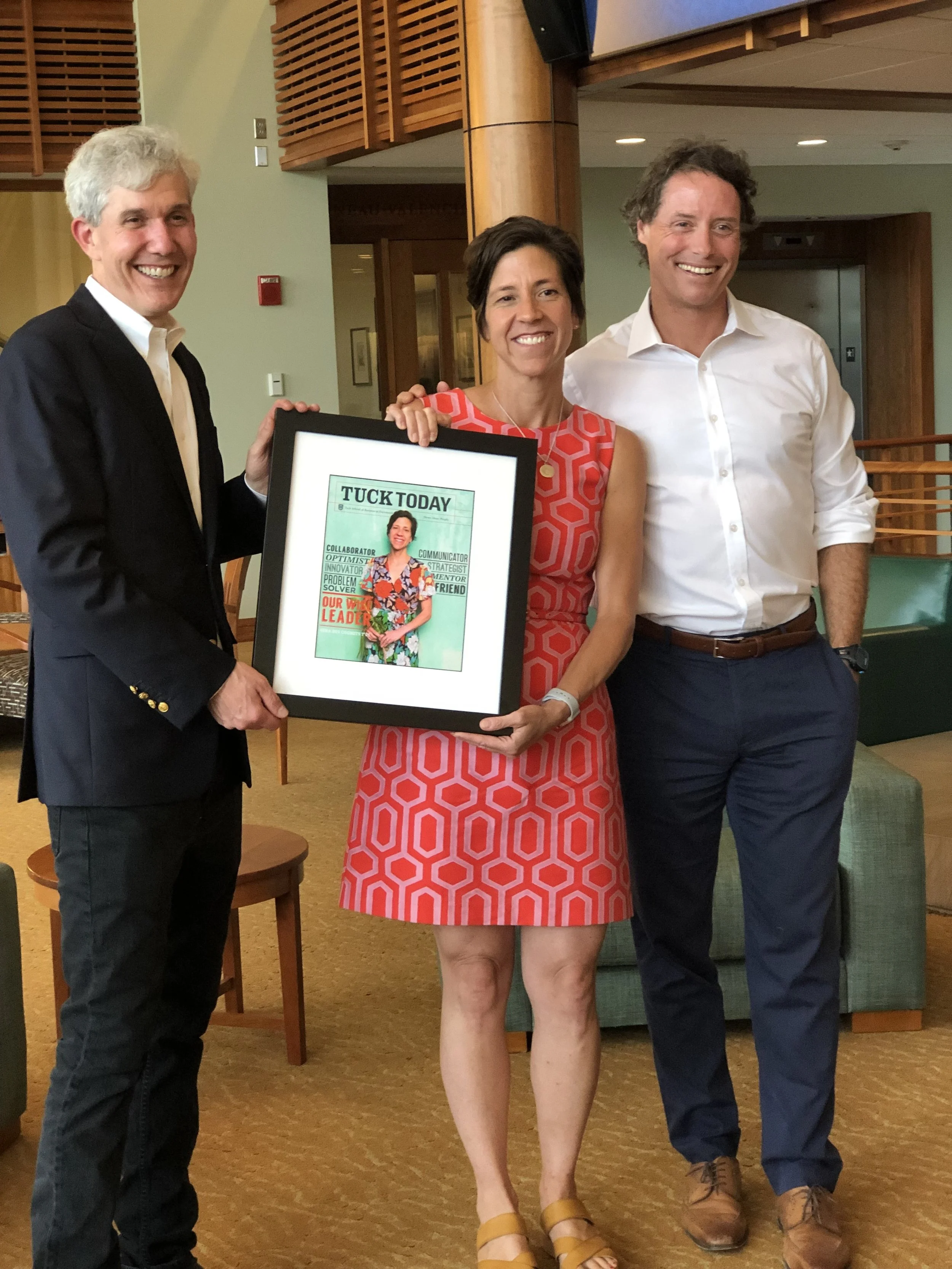 Lead with Gina coach and consultant Gina des Cognets at Tuck School of Business presentation holding framed magazine cover