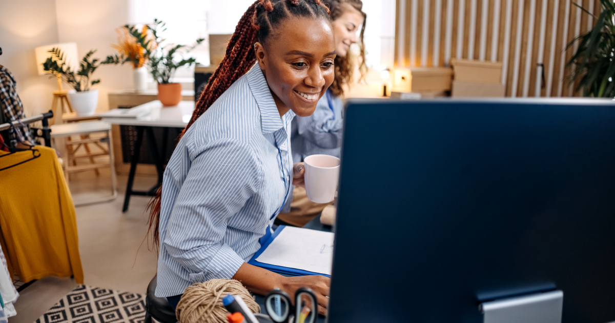 Small biz owner at computer smiling