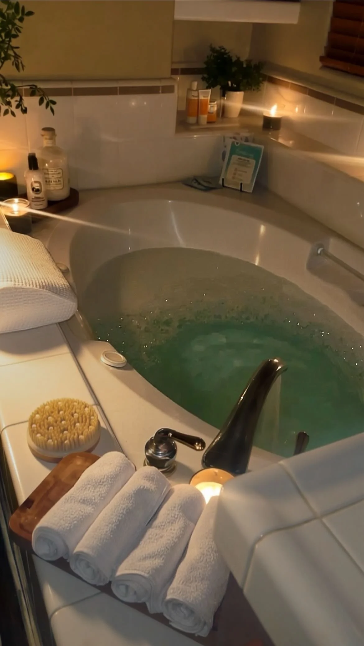 Warm bubble bath with a candle, cup of tea, and folded towels, creating a peaceful space for rest and recovery.