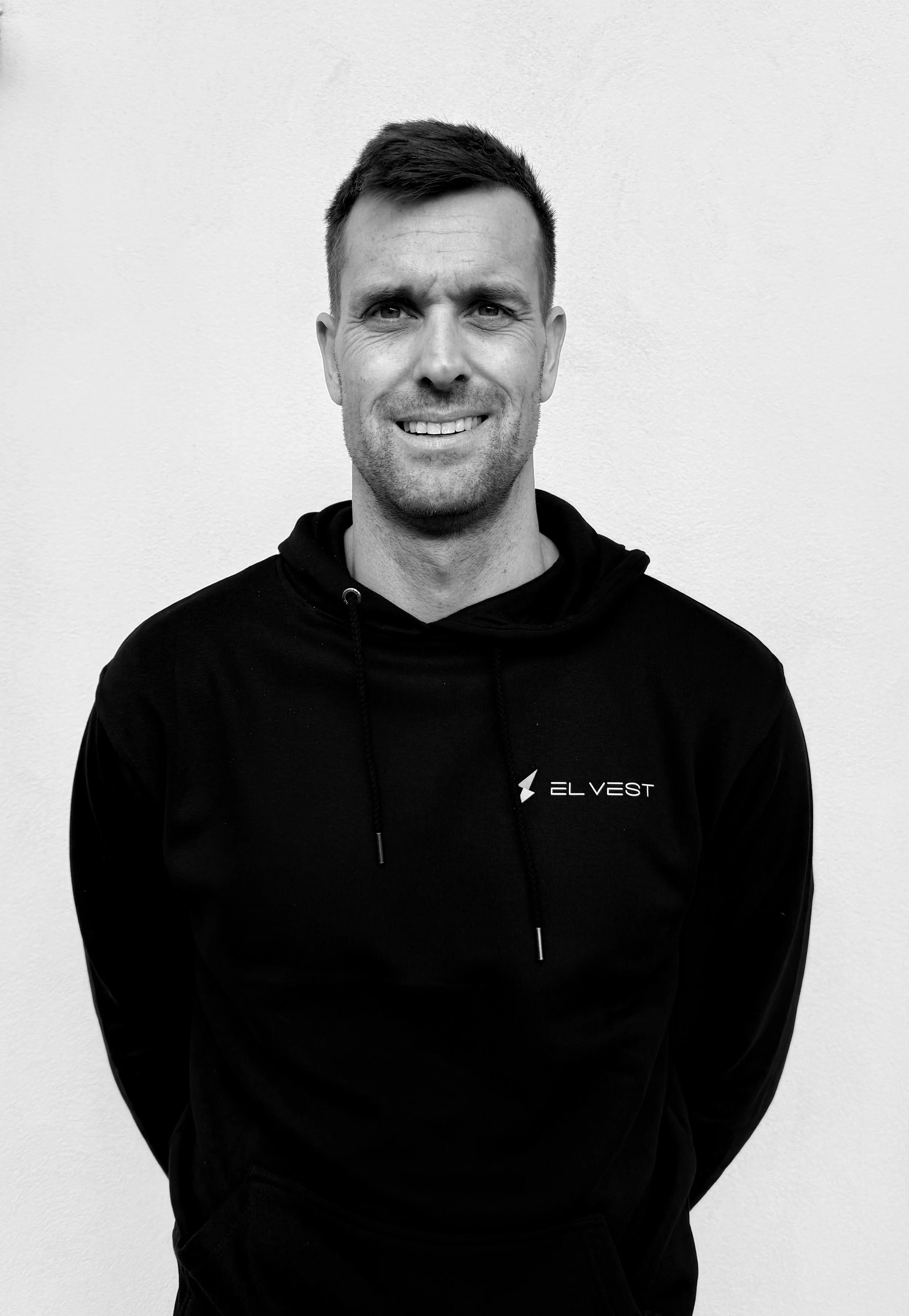 Man wearing black Elvest hoodie against white background