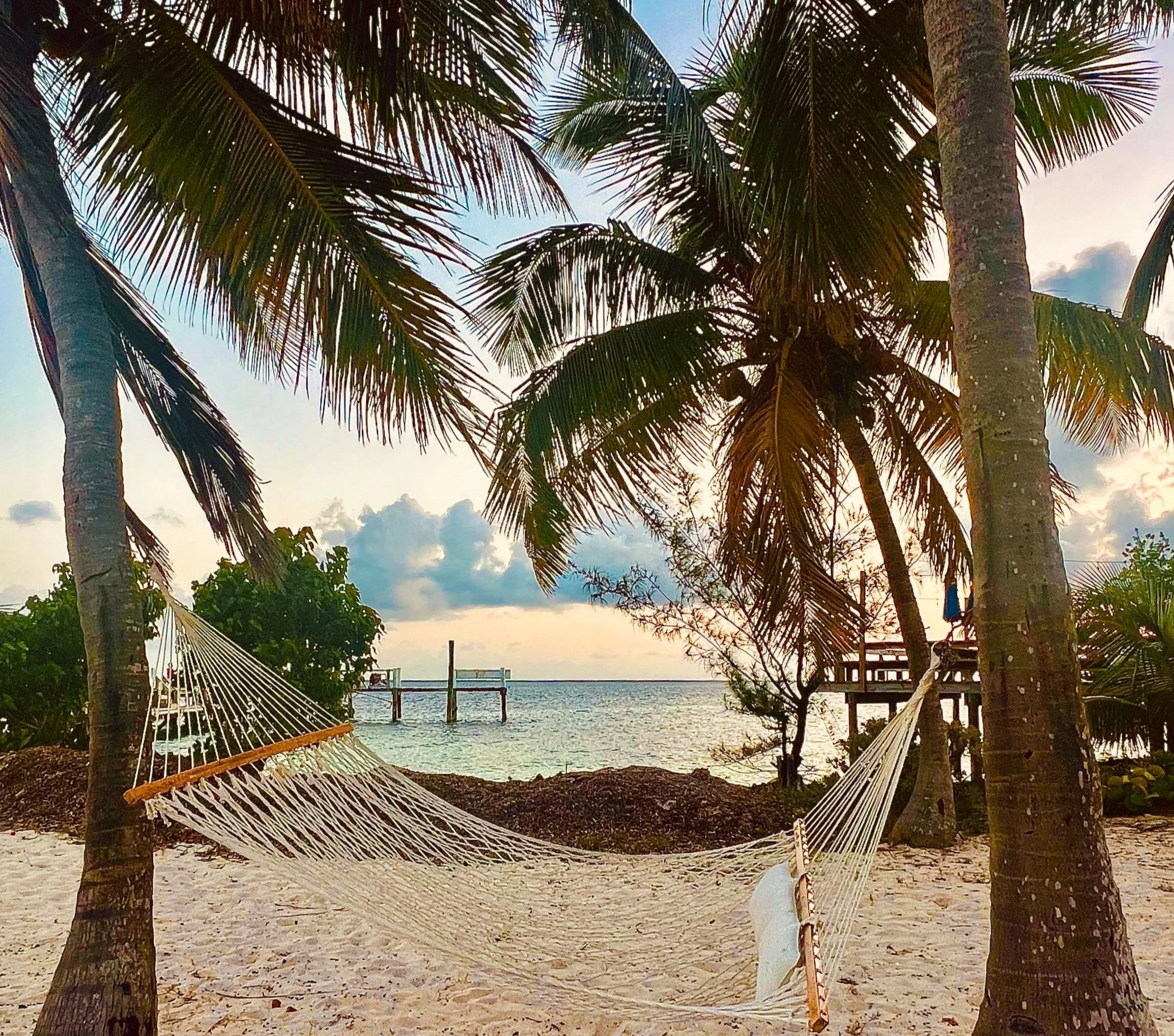 Scenic seaside view with white balustrade at sunset, mountains silhouette in background