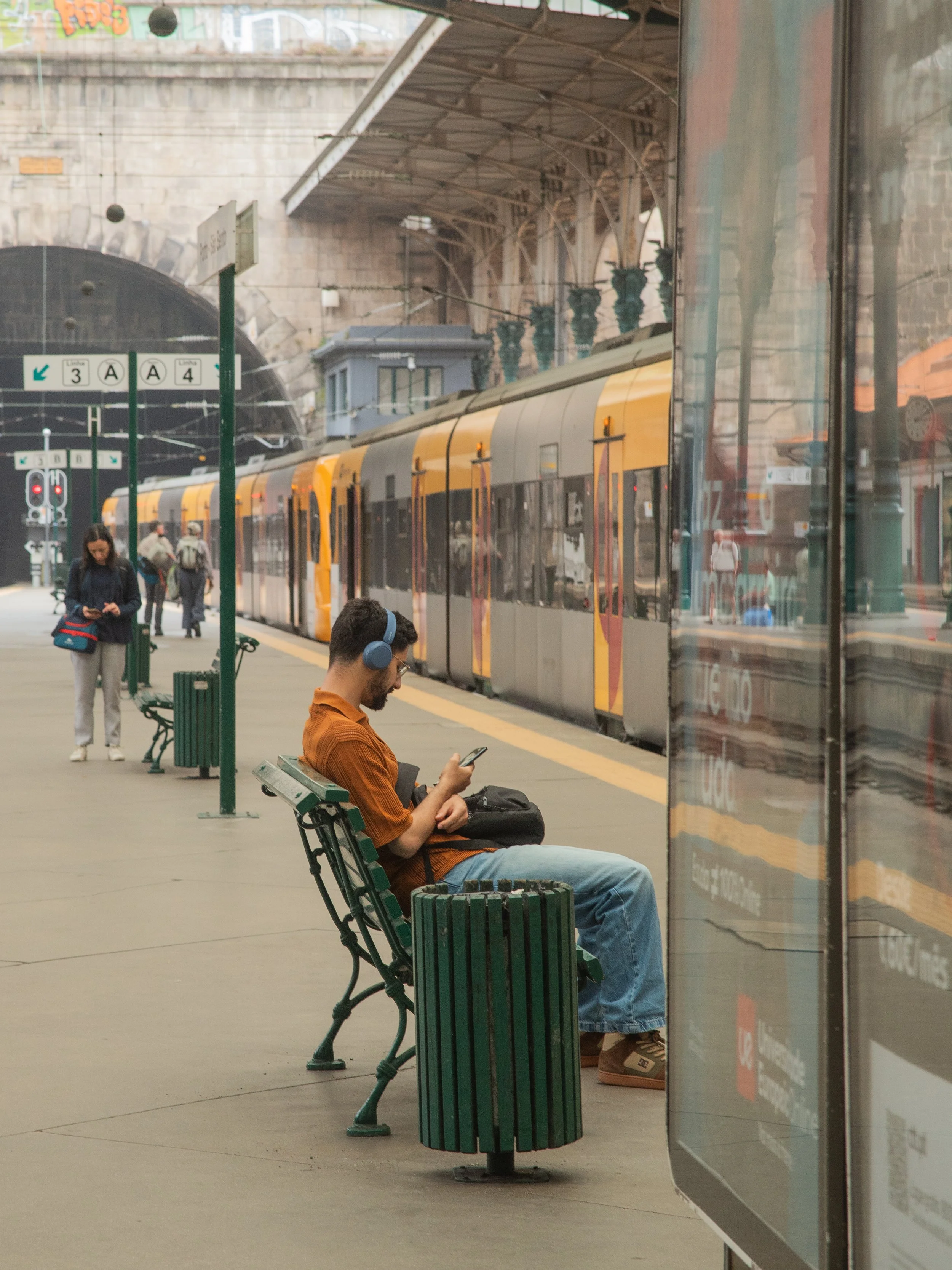 man with headphones waiting for the train