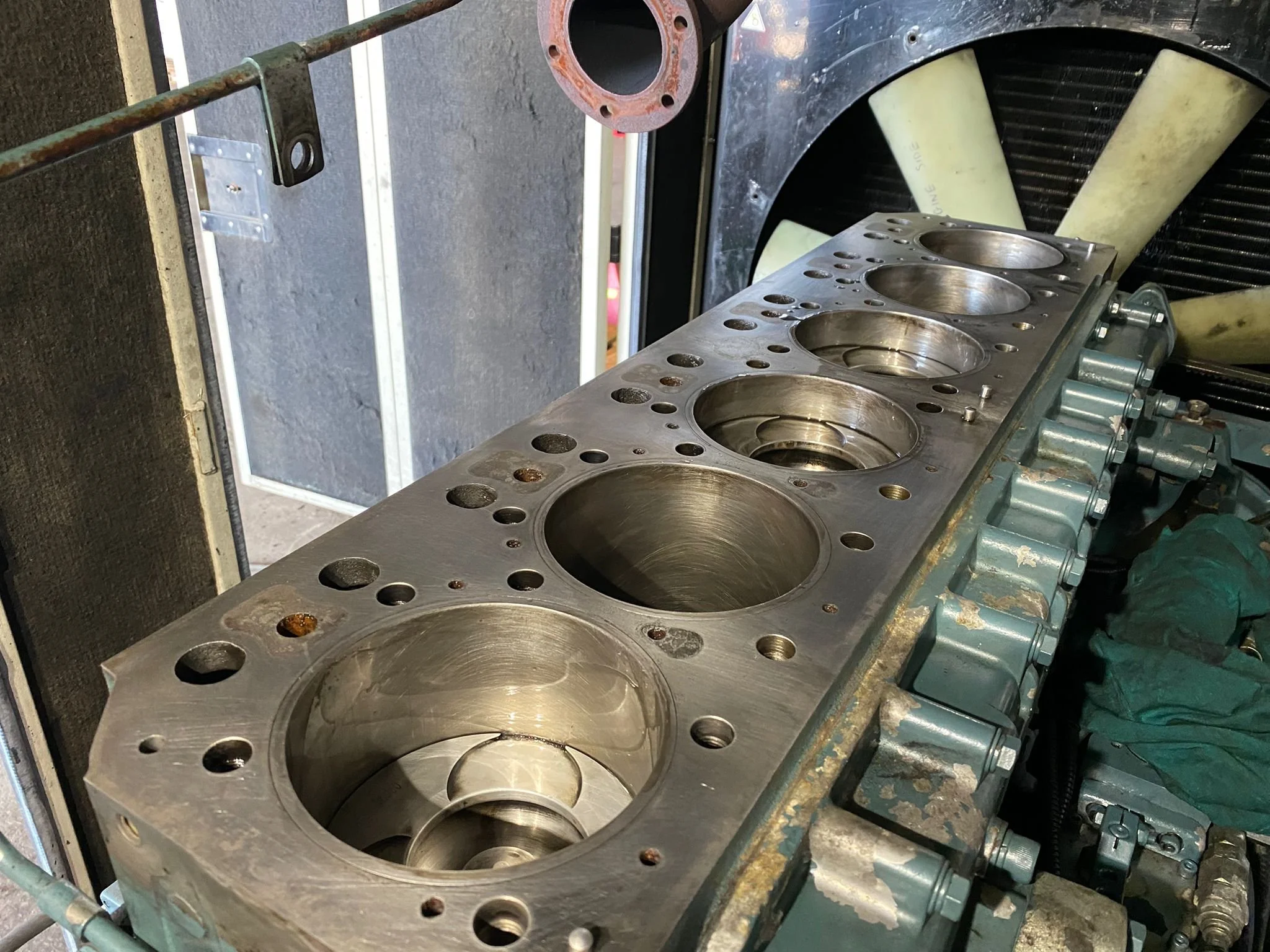 Close-up of an engine block with cylinders, on a workbench in a workshop. Diesel Generator Repair