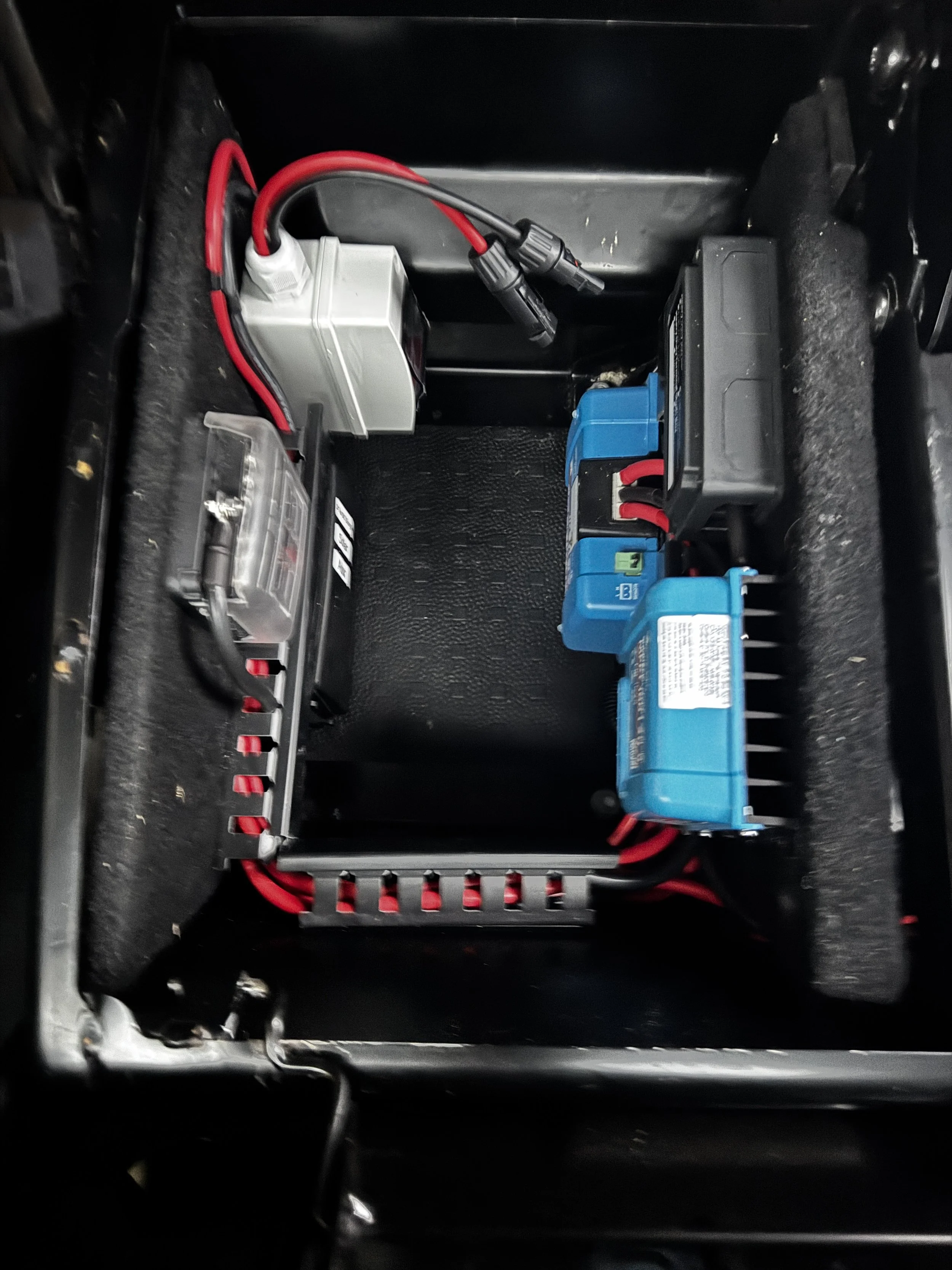 Close-up of an electrical setup with cables and components inside a black enclosure.