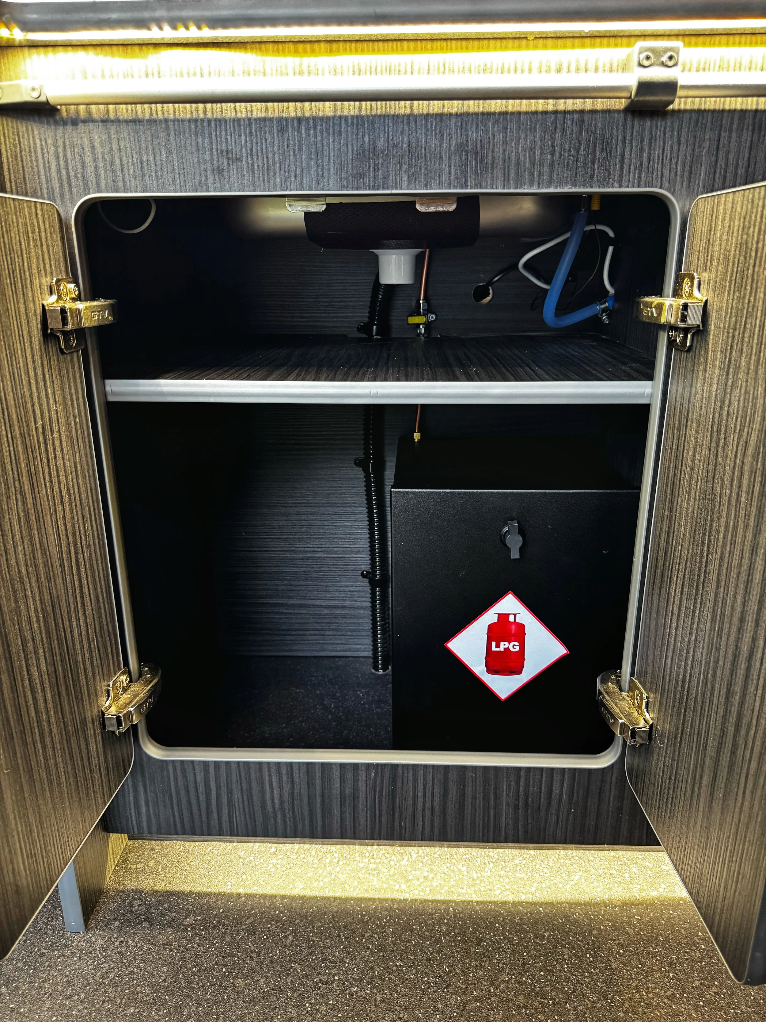 Open cabinet with gas connection and LPG cylinder sign inside