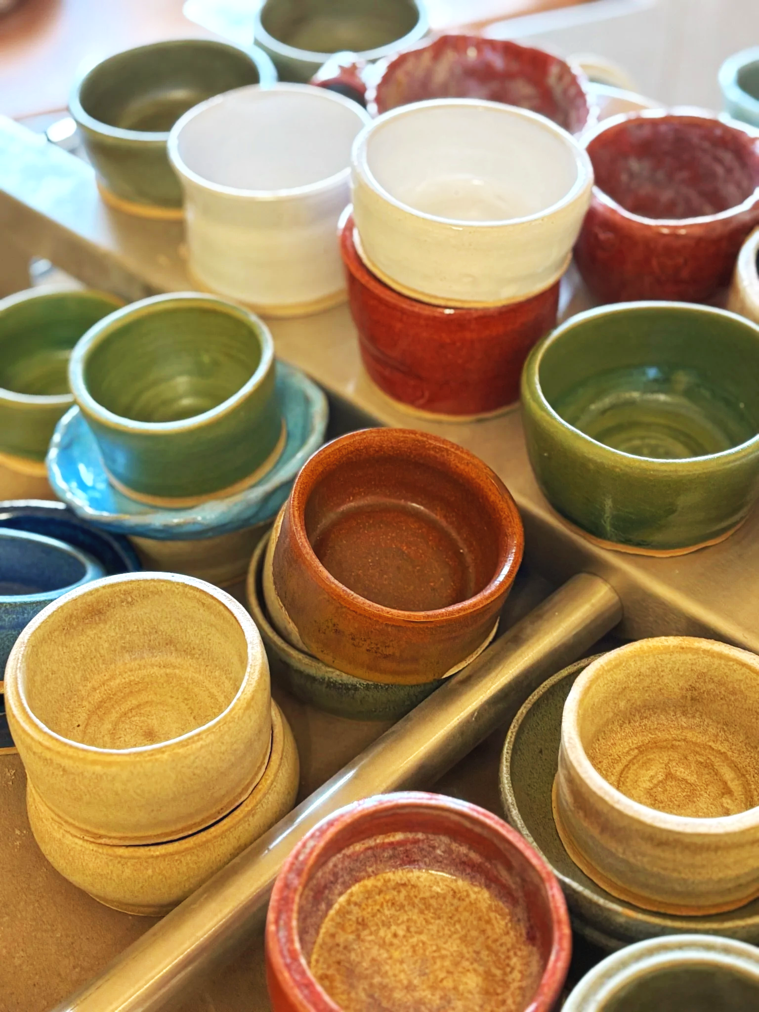 group of people making pottery on 5 potters wheels