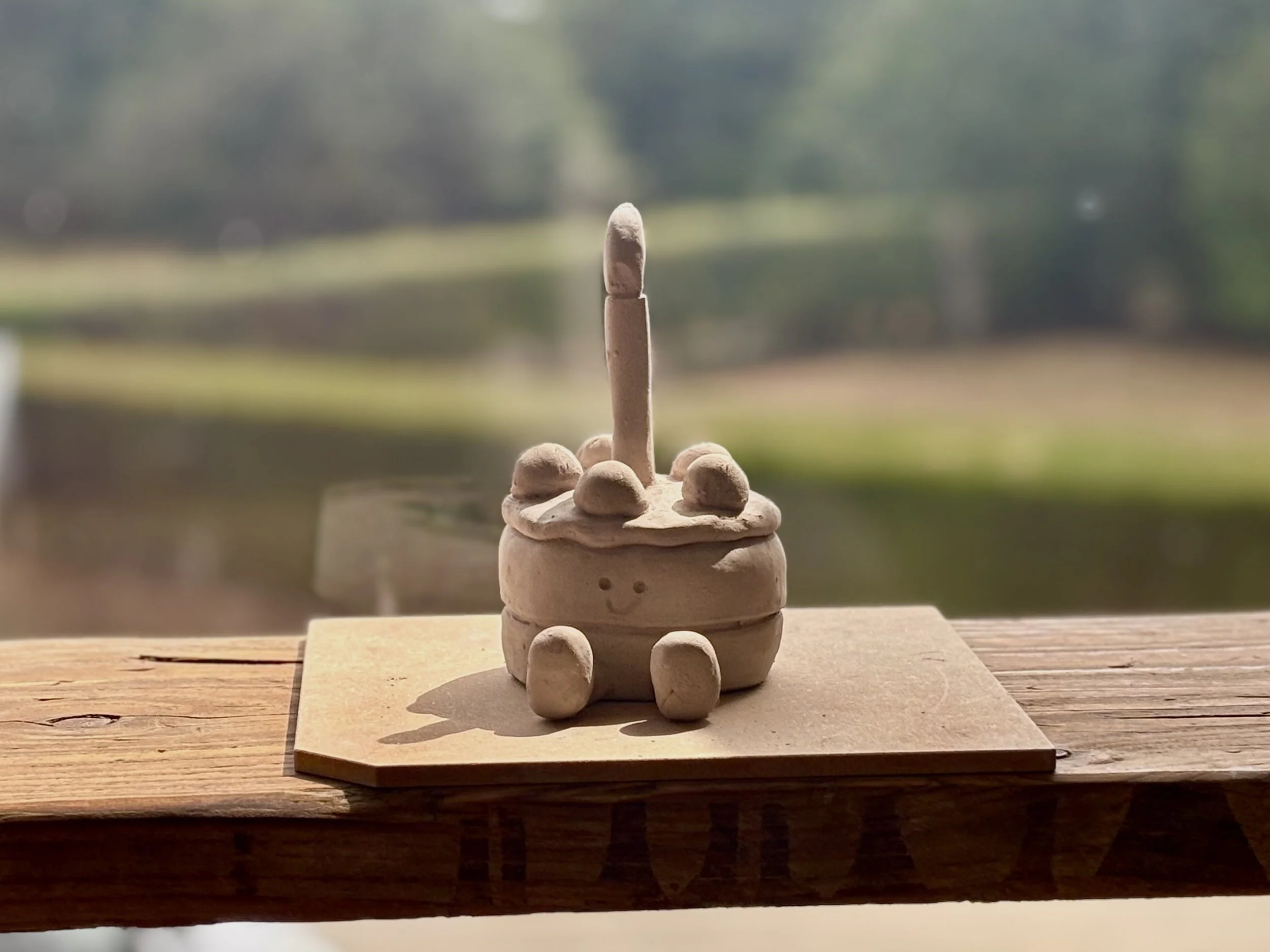 clay cake jelly cat on a wooden board displayed in the sun