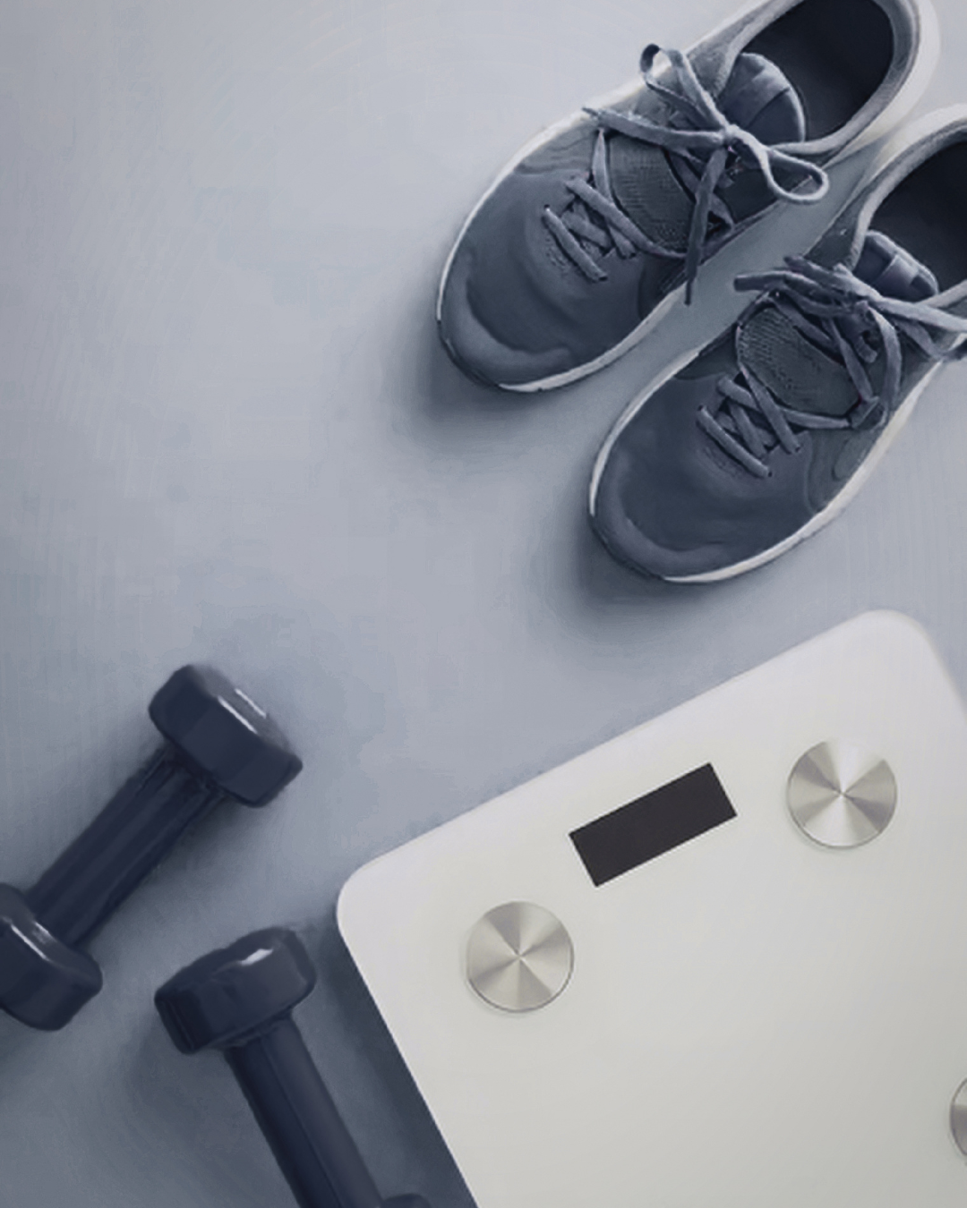 Mancuernas, zapatillas deportivas y báscula digital que representan el inicio de un programa de entrenamiento, evaluación física y transformación de hábitos saludables.