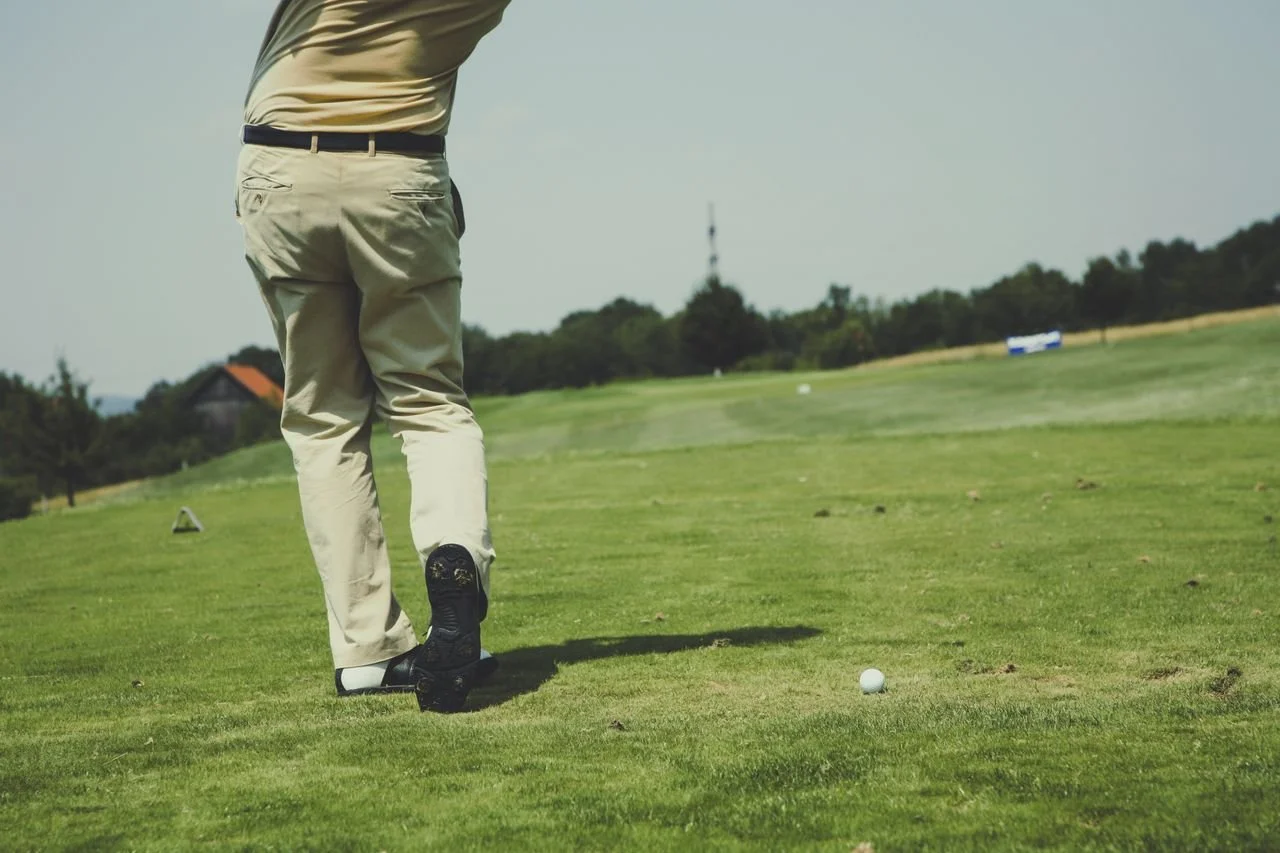 Image of a golfer mid-swing from the torso down