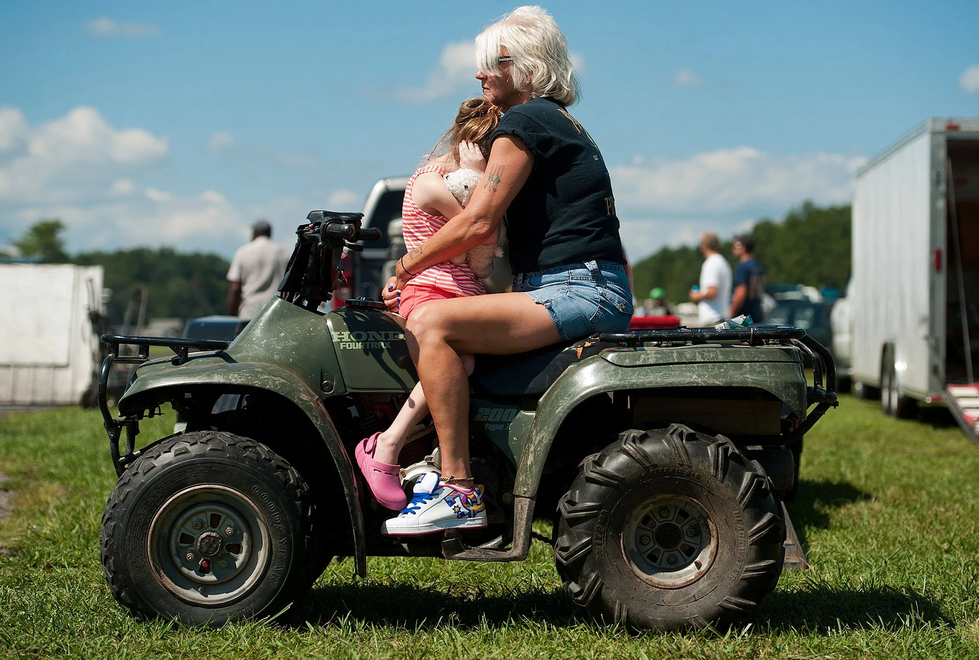 Ariana Jade Fagnani, 6, covers her ears from the loud engines and holds her stuffed bear, named Butterfly, as she buries her head into her grandmother Lori-Ann Fagnani at the New London Dragstrip in Forest, Virginia, on Aug. 24, 2013.