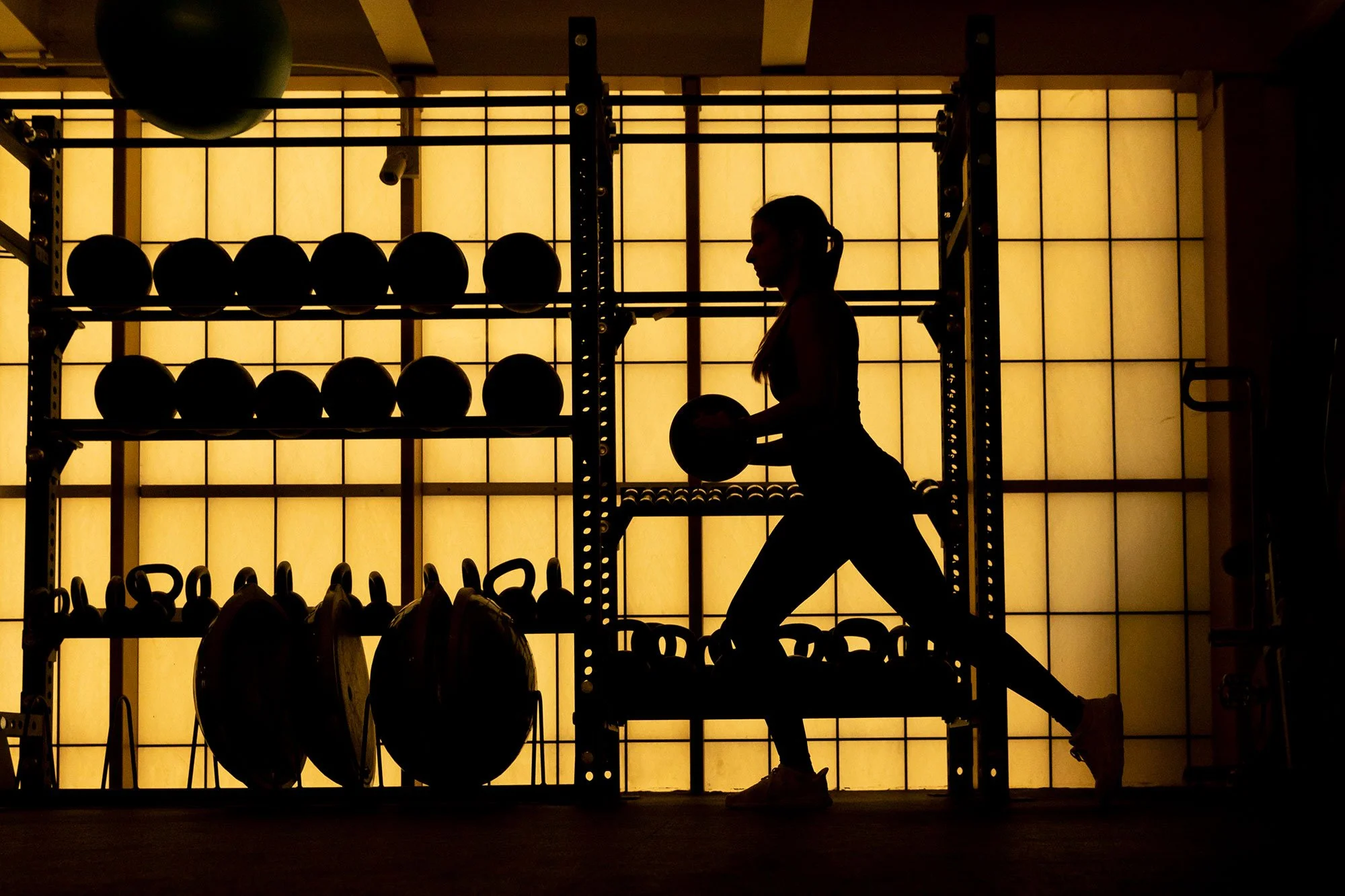 A personal trainer demonstrates medicine ball exercises near the Indoor Track in the University of Missouri Student Recreation Complex on June 16, 2022. 