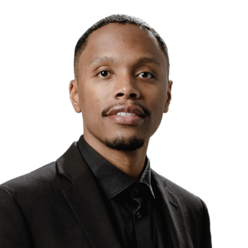 Brandon, aka DJ McWhite, wearing a black blazer and black shirt against a white background.