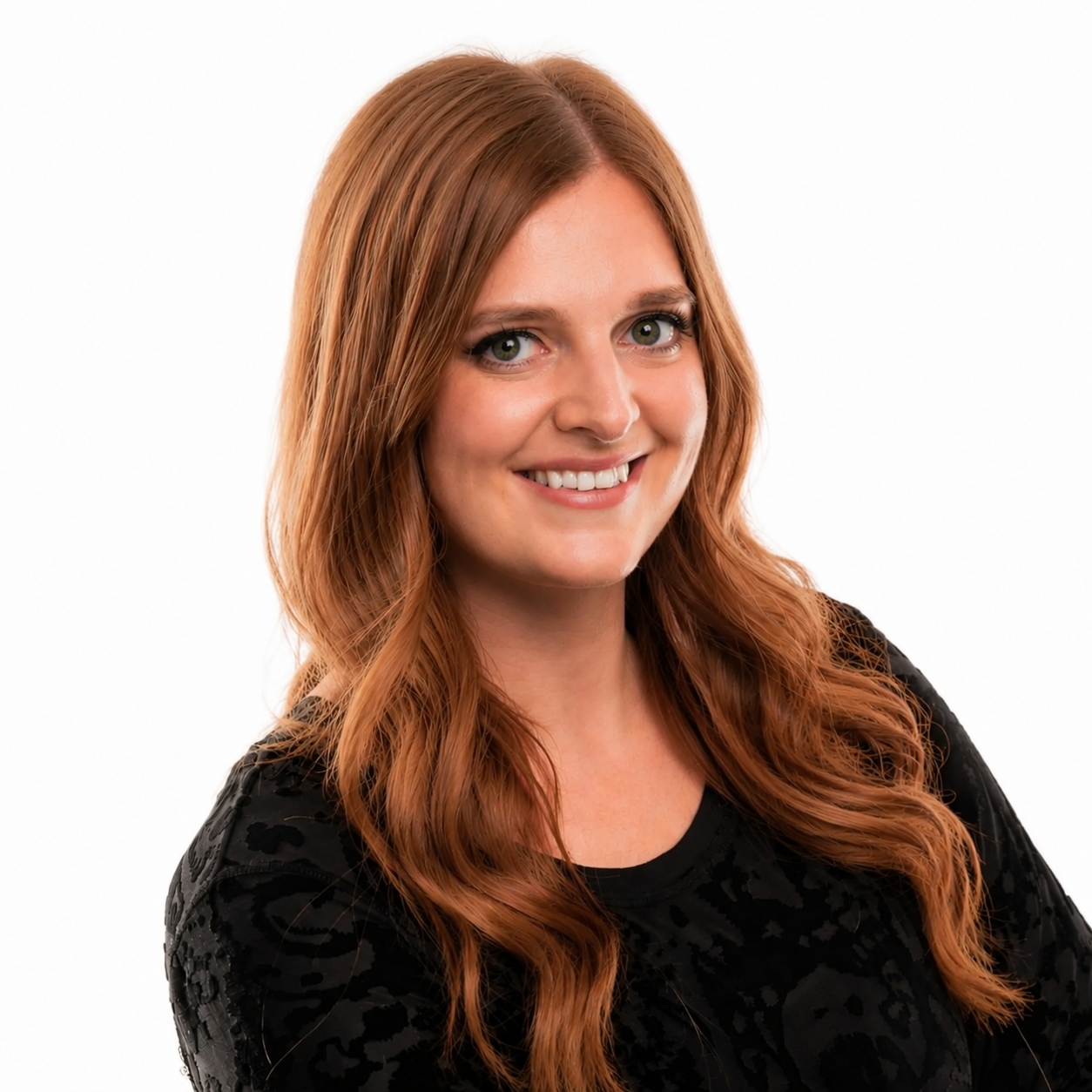 Karen, aka DJ Hemmesphere, smiling with long, wavy hair dyed in shades of blonde and purple, wearing a black patterned top, posing against a white background.