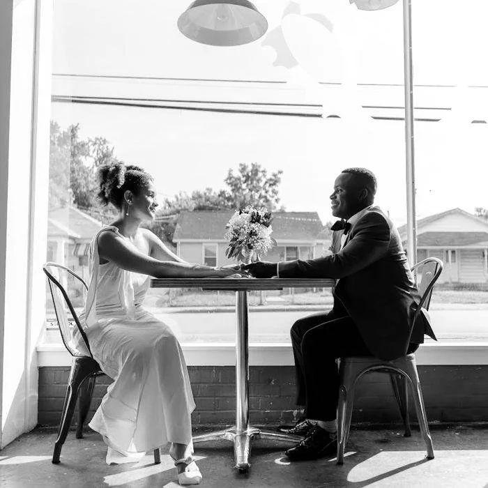 Bride and groom sitting in diner before their wedding day
