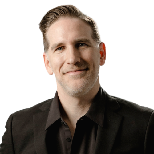 Tyler Sherman, AKA DJ Munition, wearing a black suit and dress shirt against a white background.