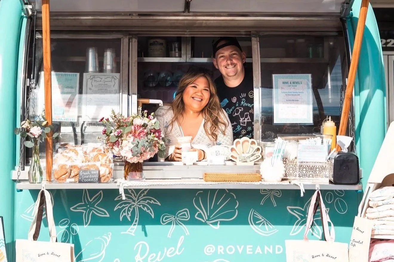 This is an image of a man and women standing inside of a blue trailer smiling