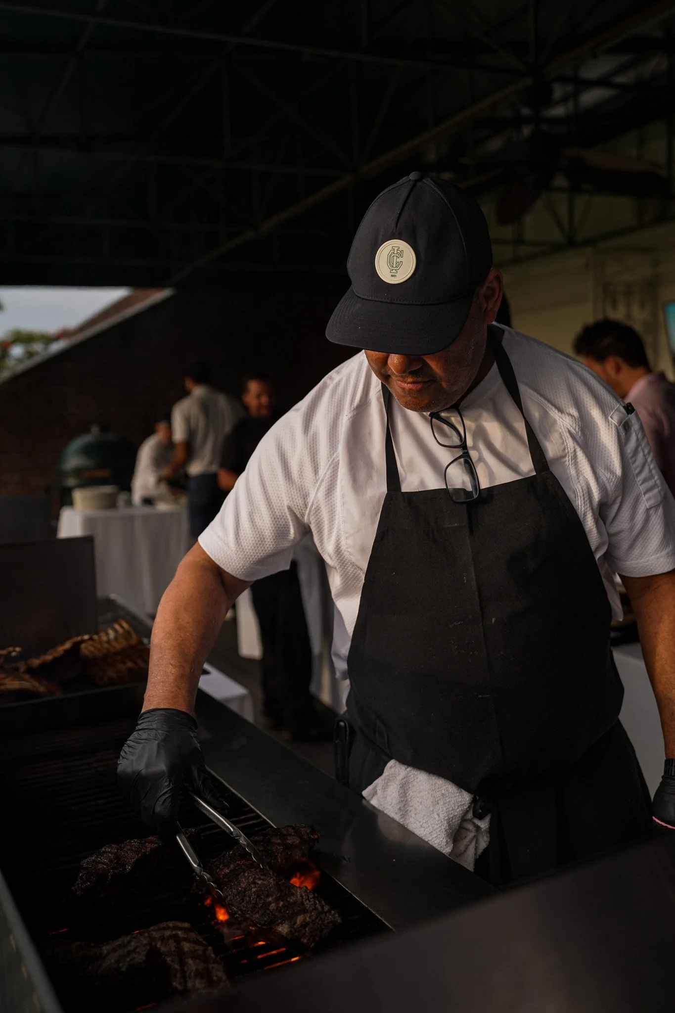 Chef preparing steaks during the Inwood Country Club Member Guest, showcasing the premium hospitality and event experiences captured by Threadline Collective.