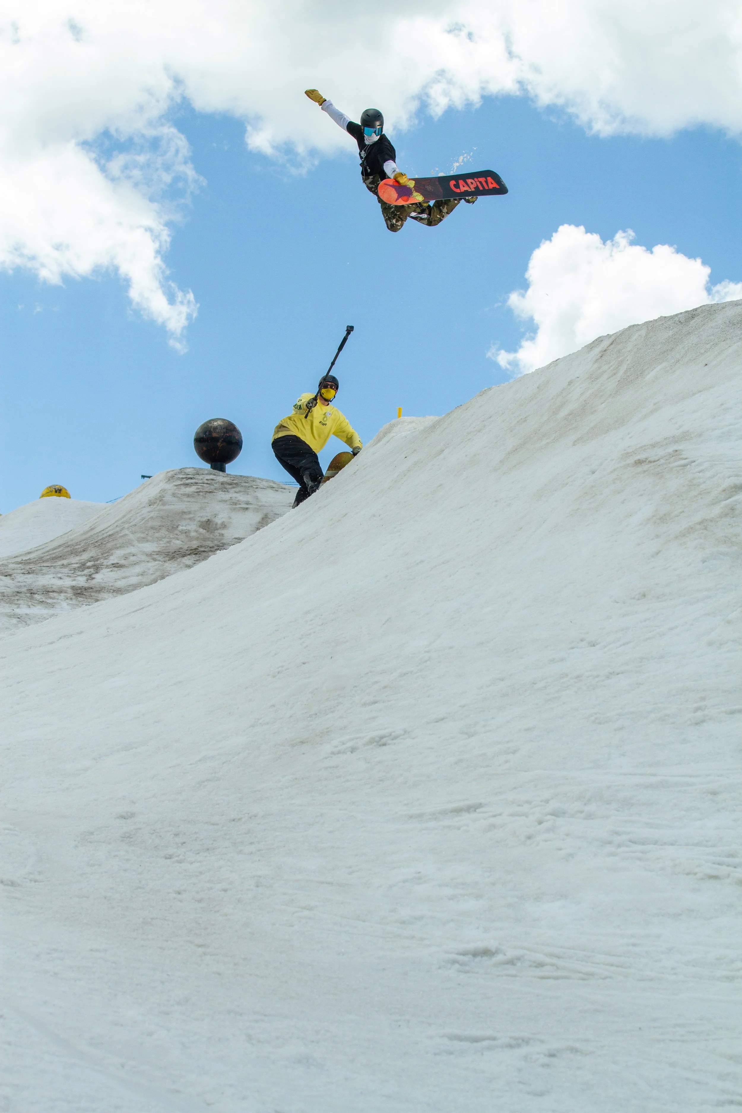 Professional snowboarder performing a rail trick at Woodward Copper during a commercial action sports production captured by Threadline Collective.