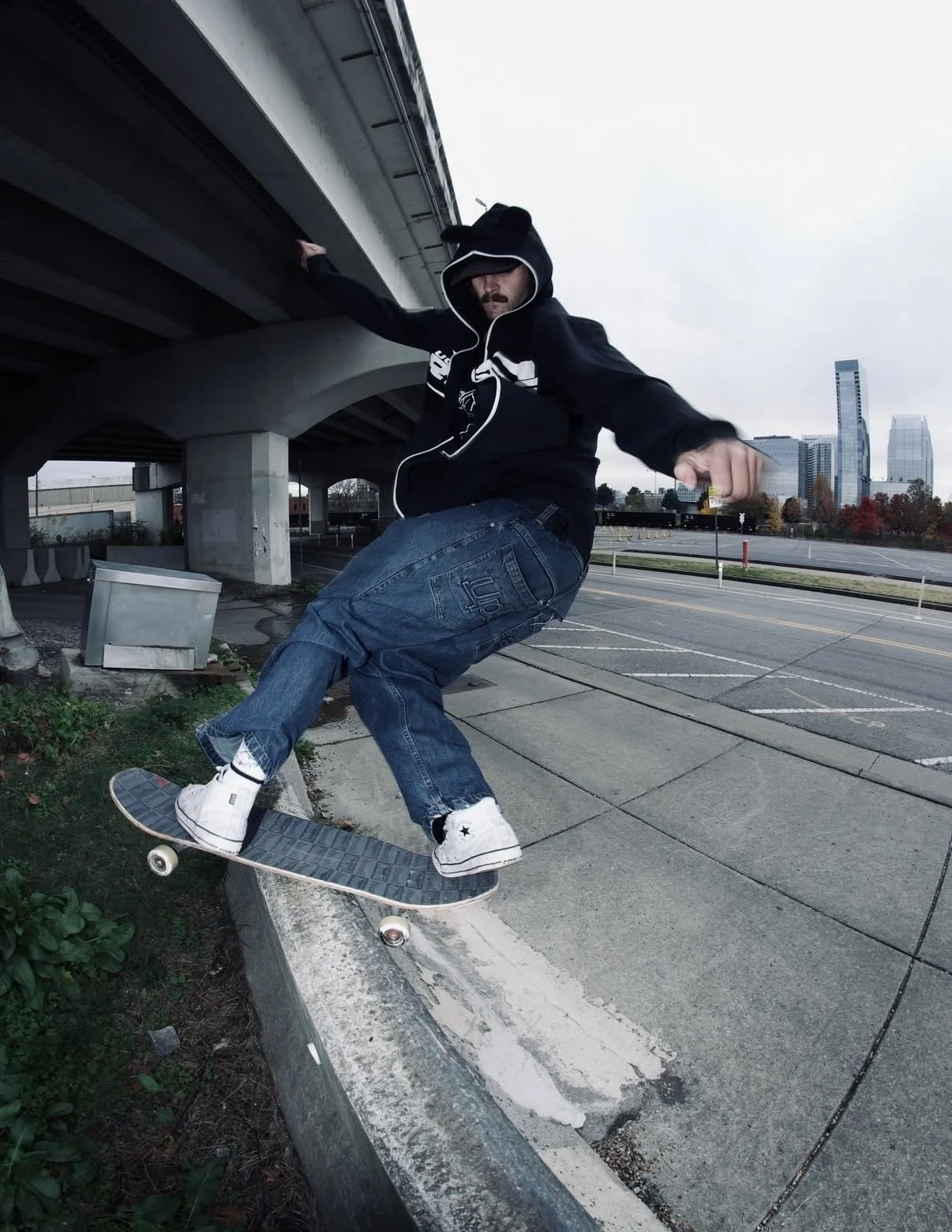 Skateboarder frontside boardslides ledge underneath overpass