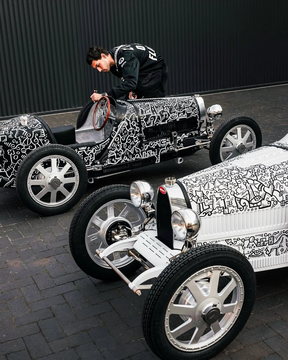 Contemporary artist Alex Alpert creating live artwork on custom Bugatti inspired vehicles during a luxury brand activation captured by Threadline Collective.
