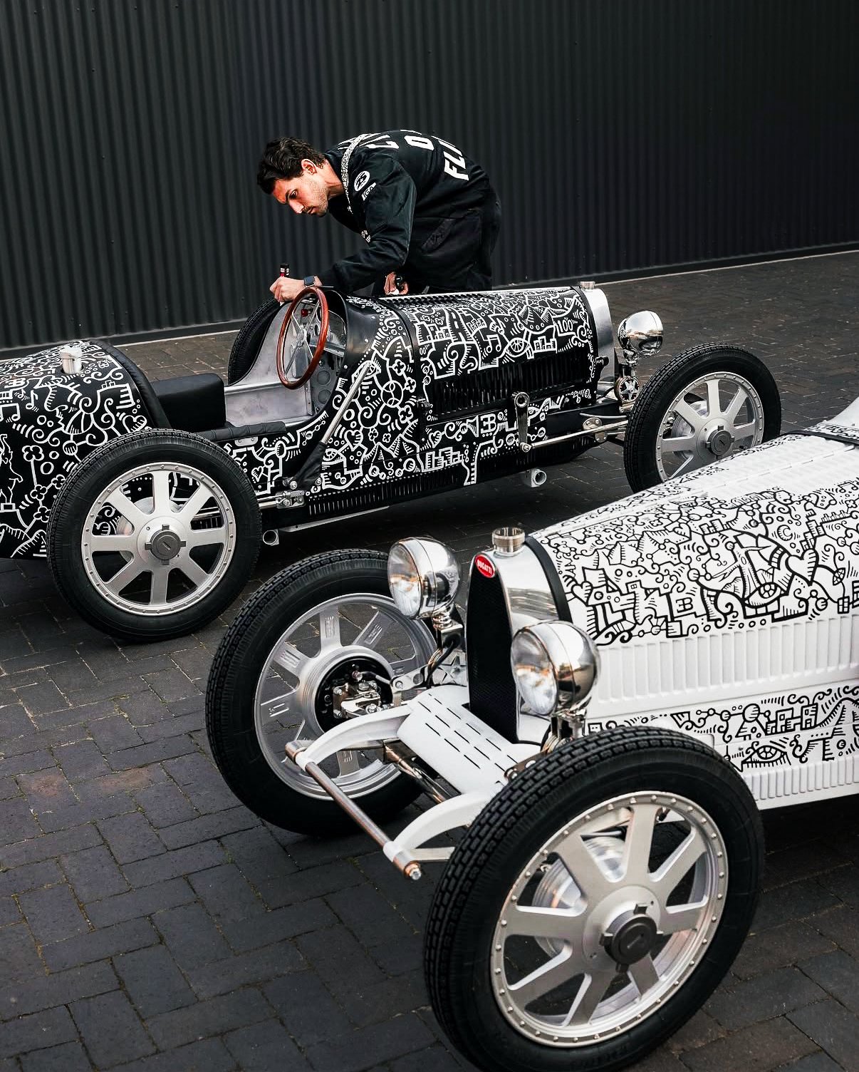 Contemporary artist Alex Alpert creating live artwork on custom Bugatti inspired vehicles during a luxury brand activation captured by Threadline Collective.
