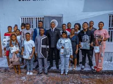 Group of students posing outside a SLUI building, some holding certificates or awards.