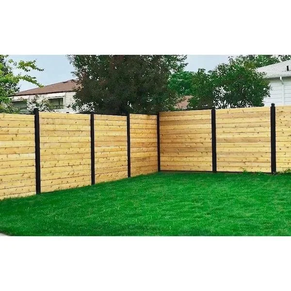 Newly constructed wooden privacy fence with black posts around a lush green lawn in a suburban backyard.