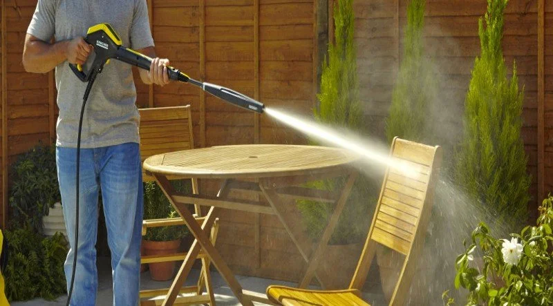 a-man-washing-garden-furniture-with-water-1.jpg