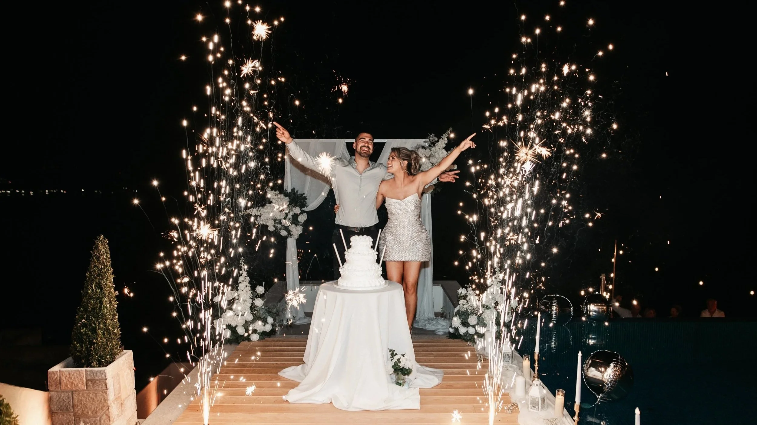 couple celebrating with pyrotechnics and wedding cake