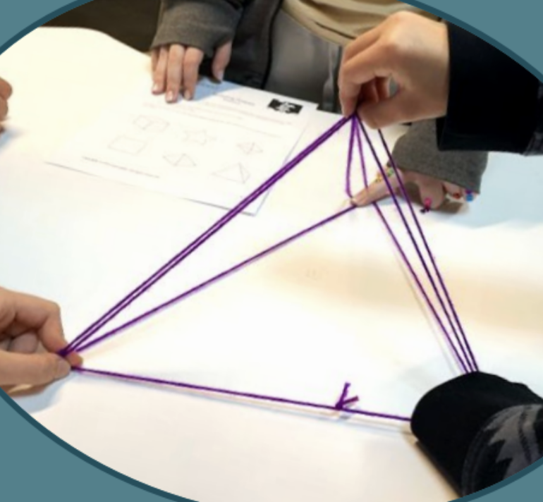 People using purple strings to create a geometric shape on a white table with worksheet papers nearby.