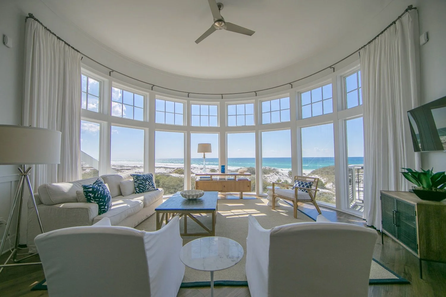 Living room with circular bay windows overlooking the beach and ocean, at Watersound, Florida.
