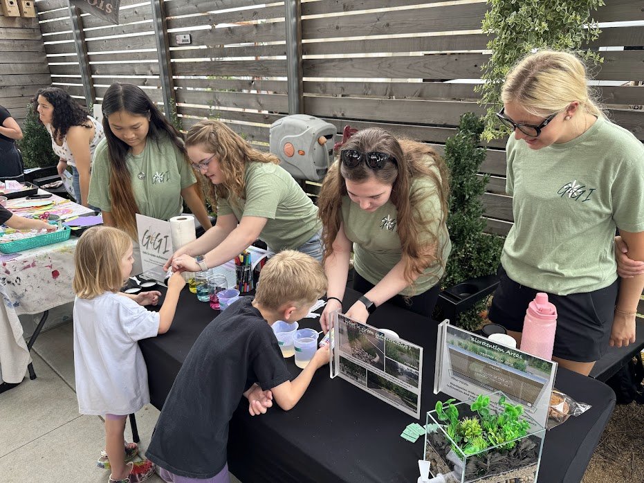 GiGI members Madelyn, Allie, Maddie, and Megan showcase green infrastructure and water quality at the StillWonder event on the Stonecloud patio, Summer 2025