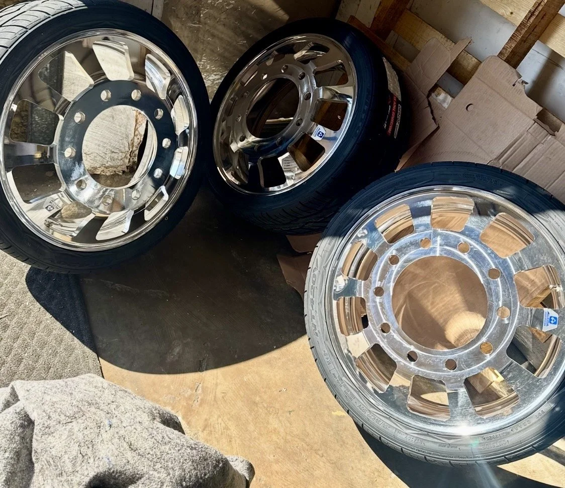 Three polished aluminum dually truck wheels with tires that show 2 of the wheels that are faced and the left wheel shows the original height, that would be the front wheel and the other two are inner wheels.