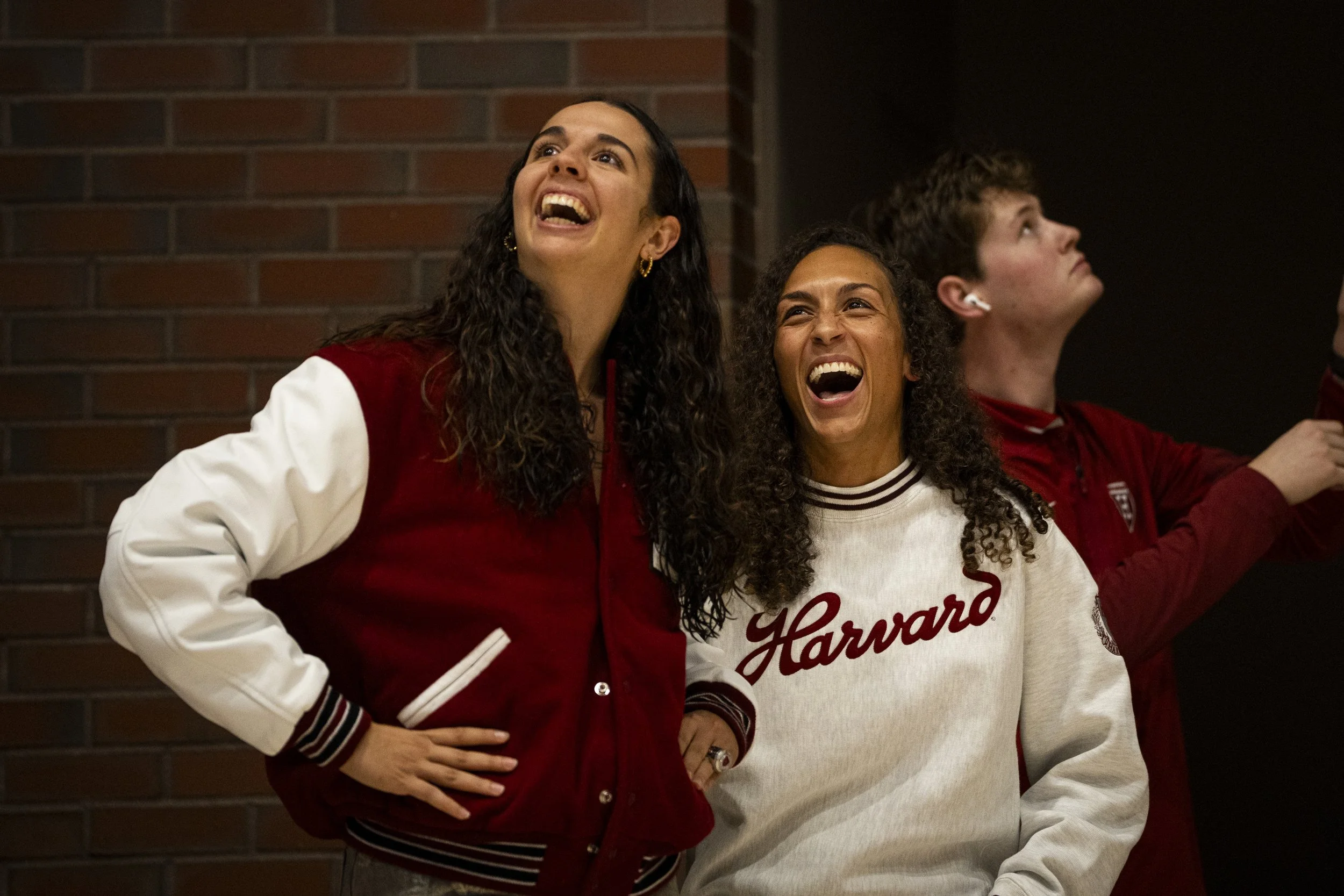 CAMBRIDGE, MASSACHUSETTS - NOVEMBER 7: Head coach Carrie Moore and alumn Elena Rodriguez react during Harvard Women’s Basketball’s Ivy League Championship banner unveiling prior to the game against St. John’s at Lavietes Pavilion on November 7, 2025 