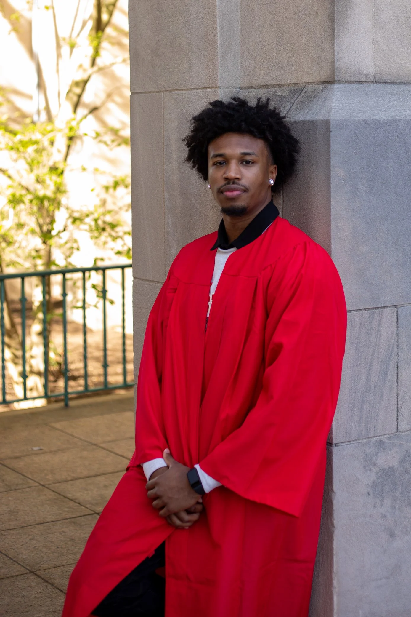BOSTON, MASSACHUSETTS - APRIL 30: Ethan Okwuosa of Boston University Men’s Basketball poses in his graduation gown leaning against the Marsh Chapel archway on April 30, 2025 in Boston, Massachusetts. (Photo by Max Elliot/Boston University Athletics)