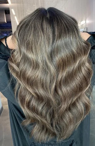 Hair Color - Long wavy brown hair from the back in a salon setting.