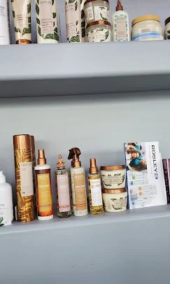 Shelf displaying various cosmetic products, including lotions, sprays, and creams in different sized bottles and jars.