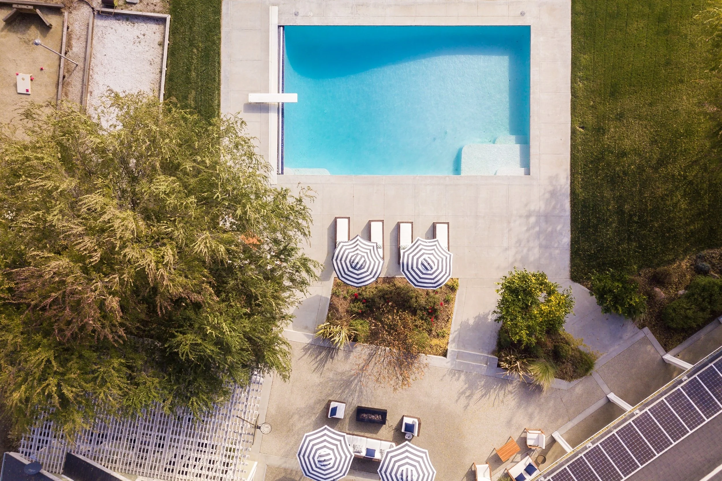 Vacation Rental photography in Souther California near Carlsbad. Drone view of pool-side amenities and with clear blue water, outdoor dining and an an area to sun-tan.