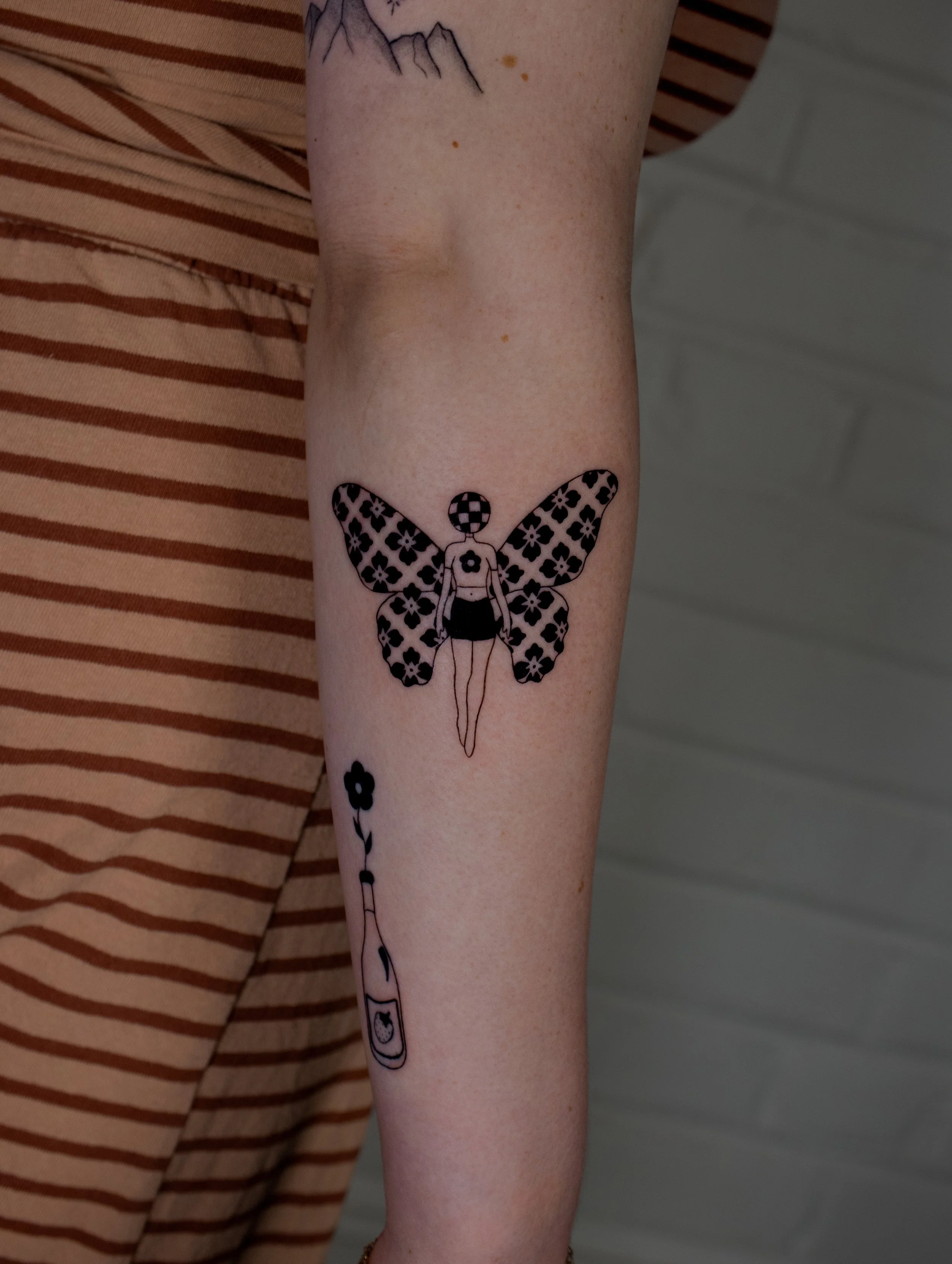 Surreal woman tattoo with butterfly wings and a disco head in a minimalist black work art style - created by Erica Inagaki in Denver Colorado