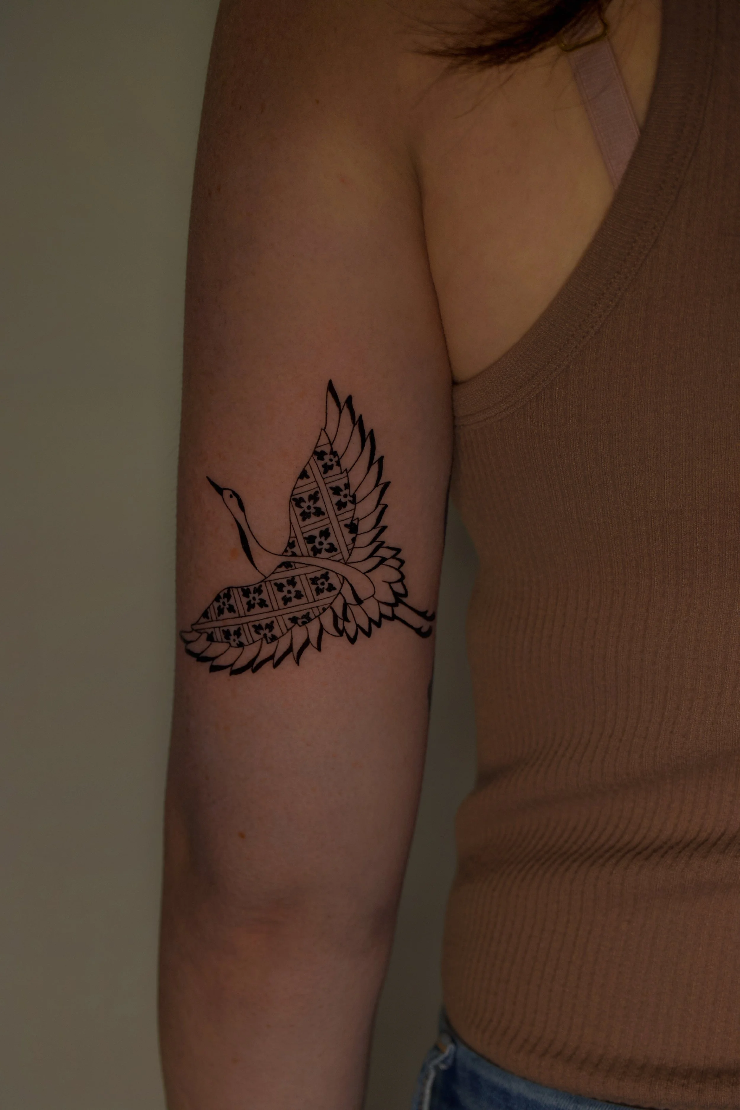 Black work tattoo of a bird (Crane) with geometric patterns on the wings - fun tattoos of animals by Erica Inagaki in Lakewood Colorado