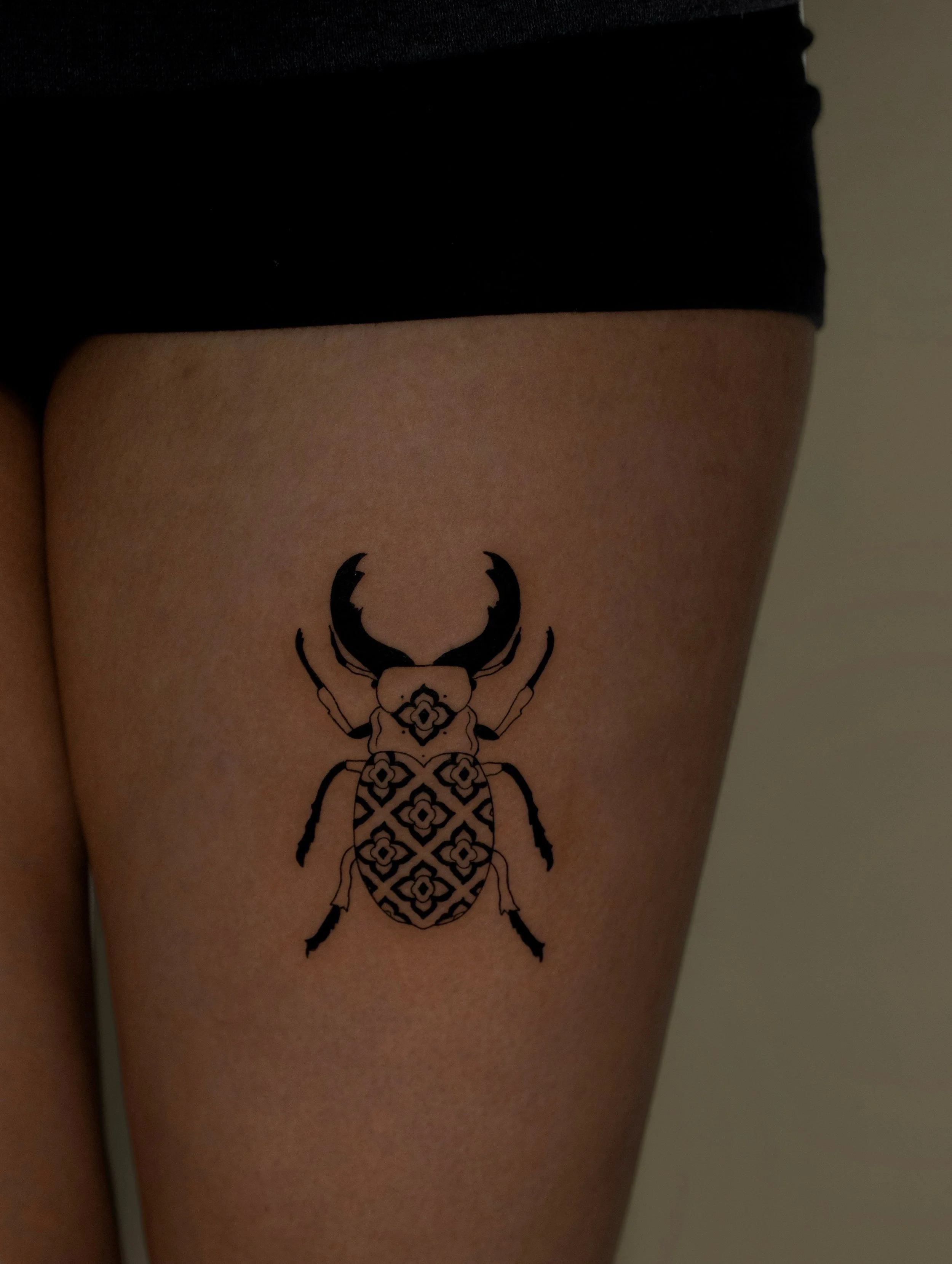Fine Line Beetle tattoo with a geometric pattern in a minimalist art style - created by Erica Inagaki in Lakewood Colorado