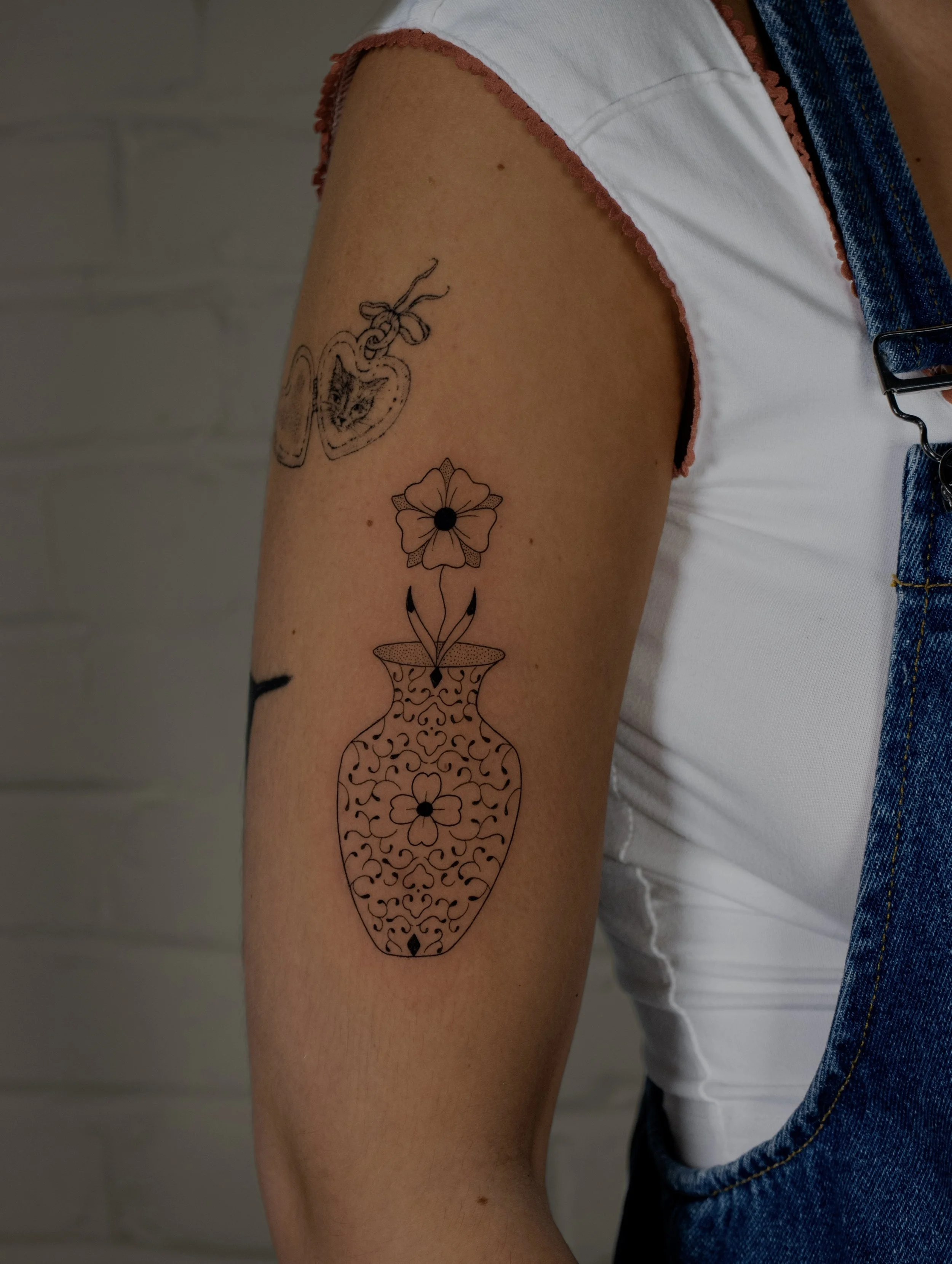 Single flower and vase tattooed in a minimalist fine line art style - tattooed by Erica Inagaki in Lakewood Colorado