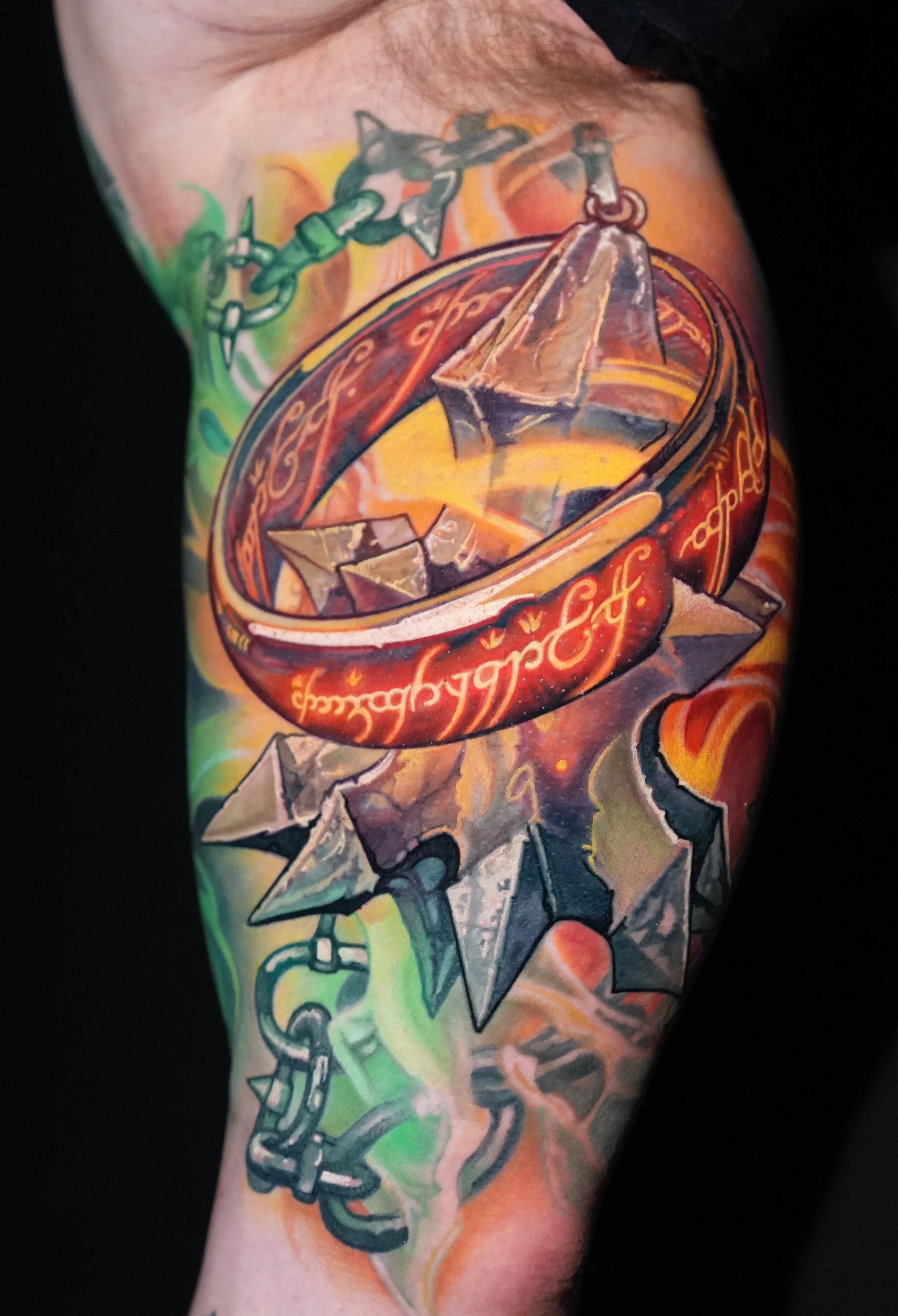 The One Ring from Lord of The Rings with spiked mace tattooed on the bicep by Danny Elliott - color realistic fire tattoo. 