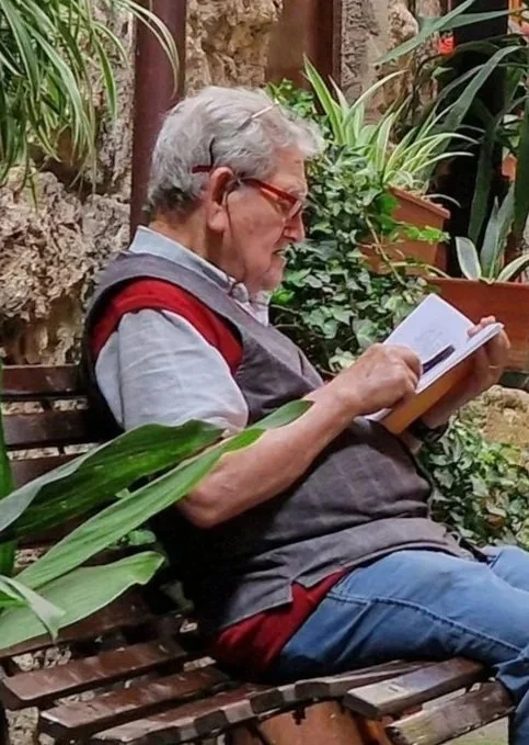 older man reading on a bench
