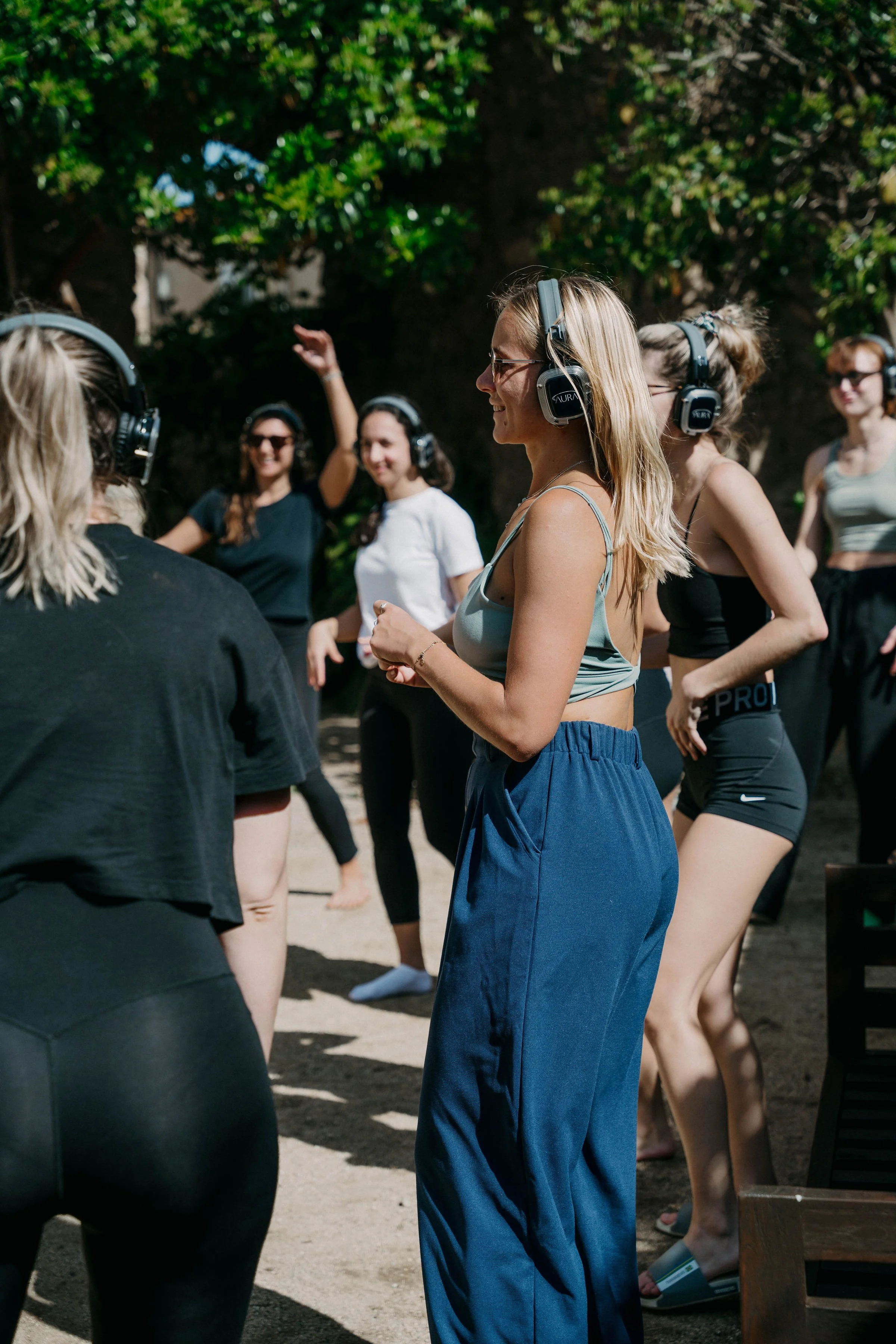 Group practicing an outdoor activity with wireless headphones during a Held Retreats wellness retreat