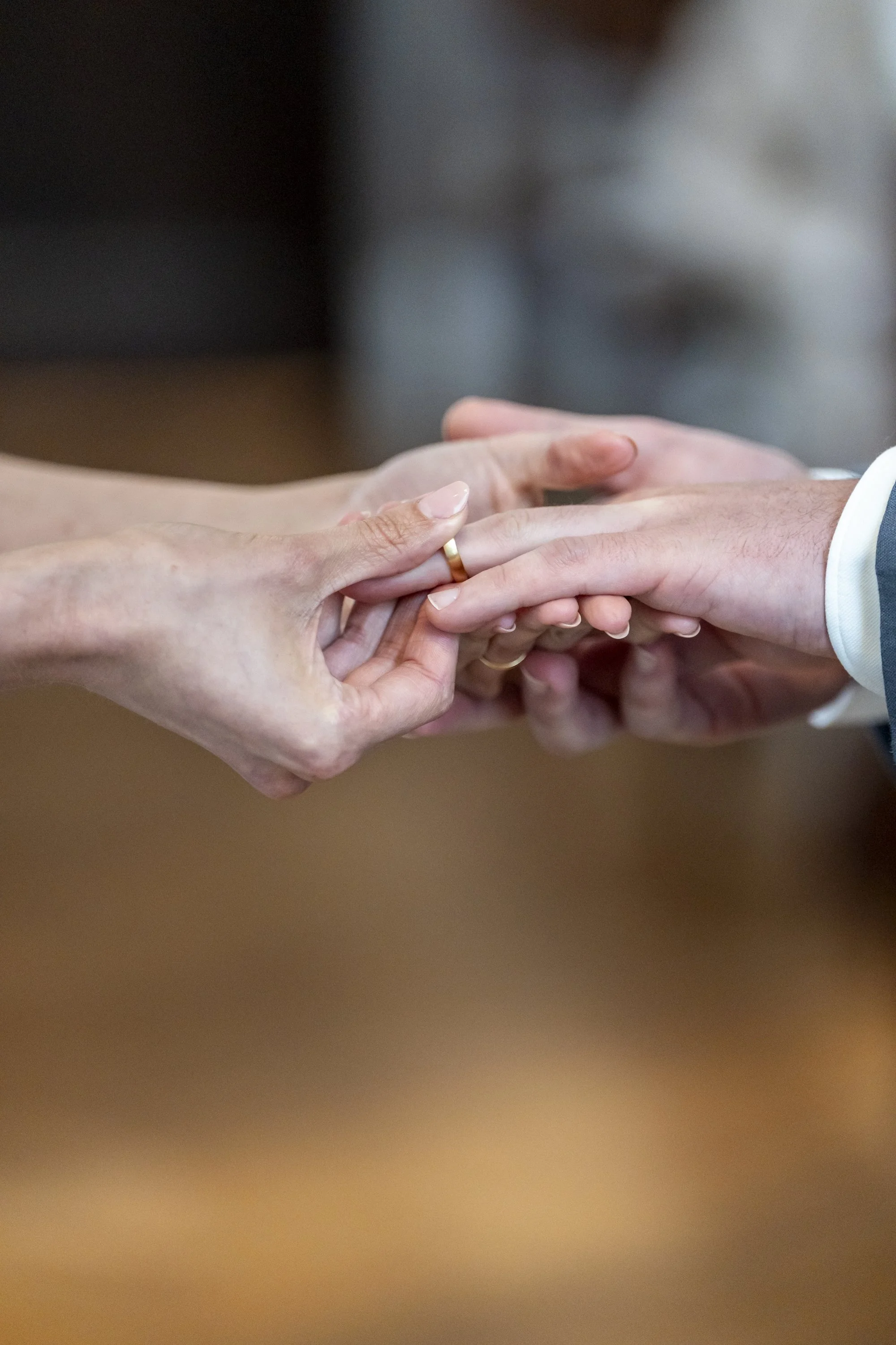 Bride and groom walking down the aisle at a rustic wedding ceremony, surrounded by guests clapping, with bunting decoration overhead.