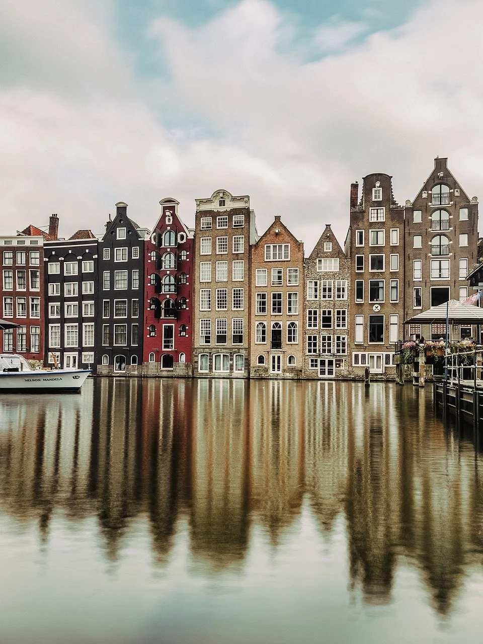 Traditional Dutch canal houses reflecting in water, Amsterdam.