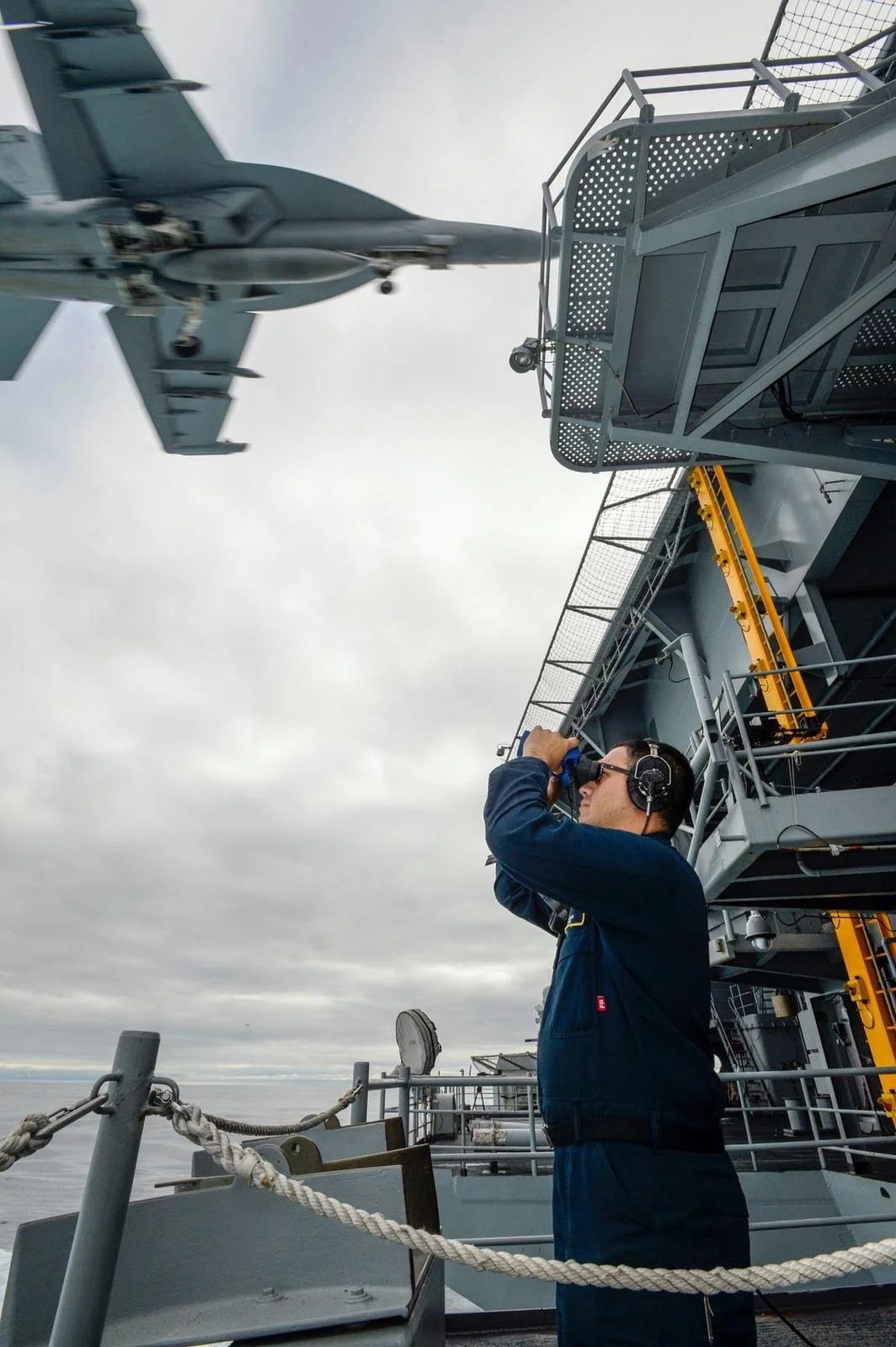 A fighter jet landing on the USS Nimitz going through an arrested landing